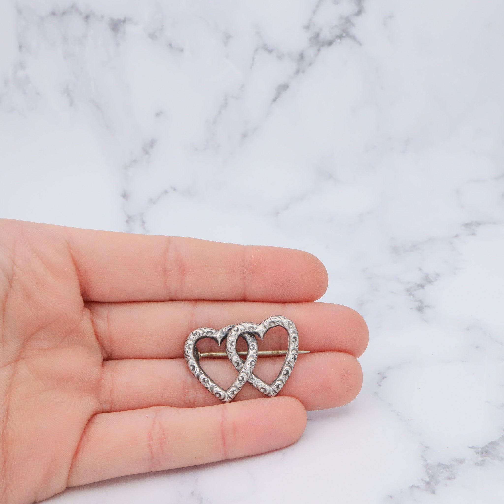 Antique Victorian sterling repousse double heart brooch